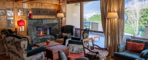 a living room with chairs and a fireplace at Gran Baita Hotel & Wellness in Courmayeur
