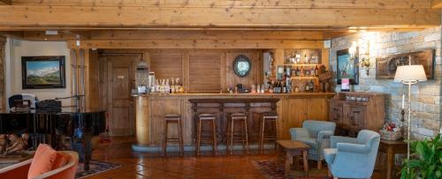a bar in a room with two blue chairs at Gran Baita Hotel & Wellness in Courmayeur
