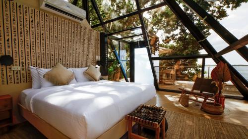 a bedroom with a bed and a large window at Unique Stays at Karuna El Nido - The Pyramid in El Nido