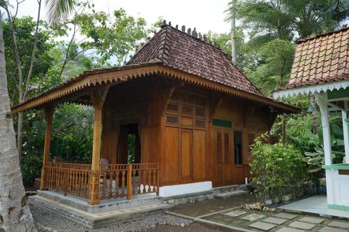 a small wooden house with a porch in a forest at Villa Embun Batukaras in Batukaras