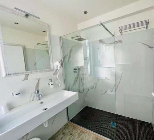 a white bathroom with a sink and a shower at Hotel Cuba Aeroport Restaurant in Rimini