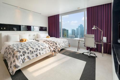 a hotel room with two beds and a window at W Bangkok Hotel in Bangkok