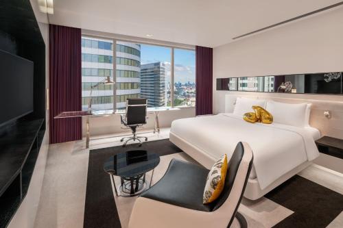 a hotel room with a bed and a desk and a chair at W Bangkok Hotel in Bangkok