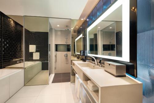 a bathroom with two sinks and a large mirror at W Bangkok Hotel in Bangkok