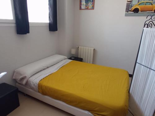 a bedroom with a bed with a yellow blanket at Alojamiento en loft Madrid in Madrid