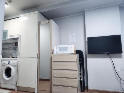 a kitchen with a microwave and a tv in a room at Urban Space Gangnam station in Seoul