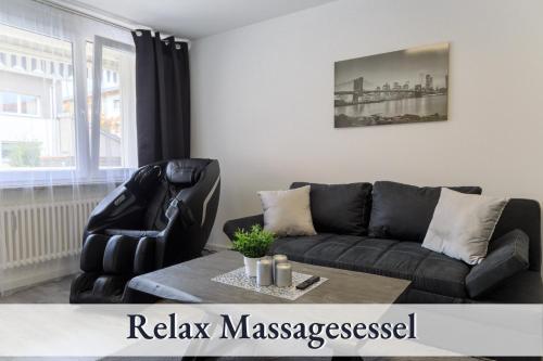 een woonkamer met een zwarte bank en een tafel bij Relax-Apartment-One FN in Friedrichshafen