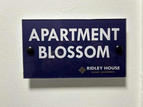 un cartel en una pared que lee el apartamento florecer en Ridley House Apartments en Yarm