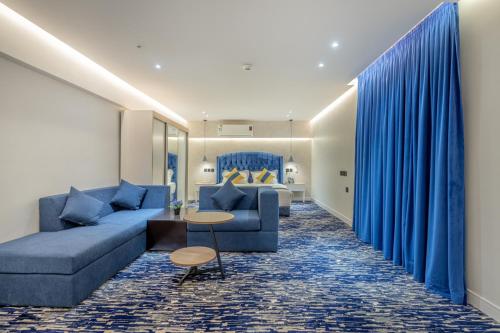 un soggiorno con un divano blu e un letto di فندق المسافر a Riyad
