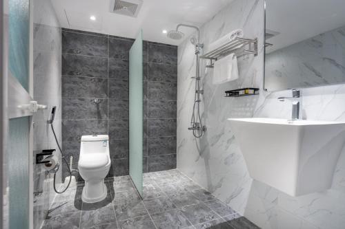 ein Bad mit einer Dusche, einem WC und einem Waschbecken in der Unterkunft فندق المسافر in Riad