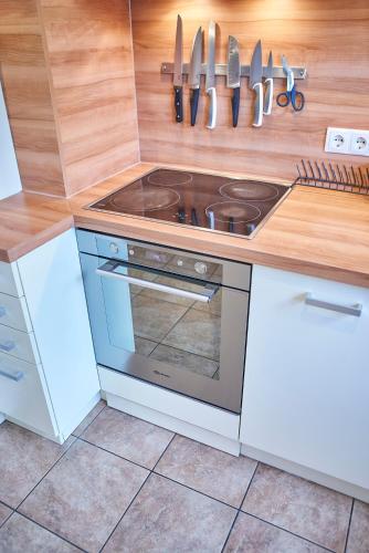 a kitchen with a stove and knives on the wall at Appartements Der Fuchsbau in Saalbach Hinterglemm