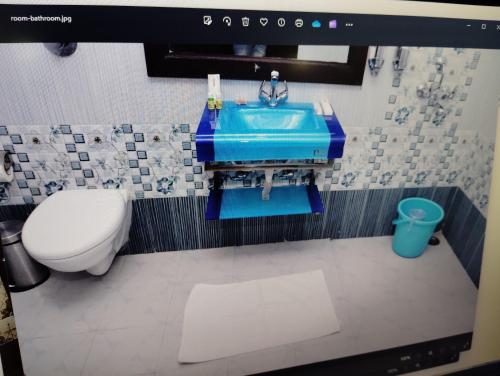 a bathroom with a blue sink and a toilet at Hotel vishnu vihar in Gaya