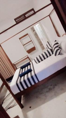 a bedroom with a bunk bed with striped pillows at Forest Rawana homestay Ella in Ella