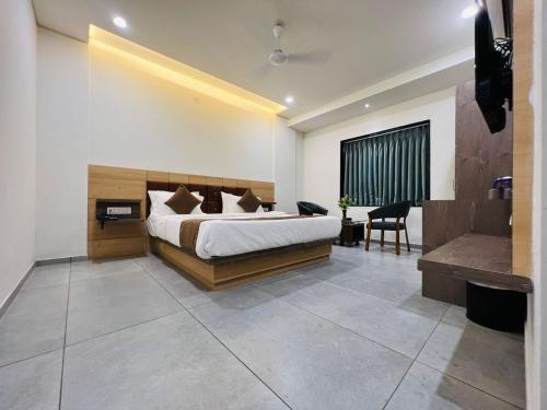 a bedroom with a large bed and a bath room at Hotel Venus By Mantram Hospitality in Rajkot