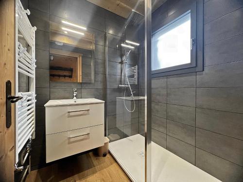 une salle de bain avec un lavabo et une douche dans l'établissement Ty Menez 2 - Chalet sur les pistes, à La Clusaz