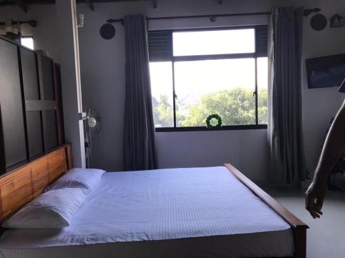 - une chambre avec un lit et une grande fenêtre dans l'établissement Sky home stay, à Kandy