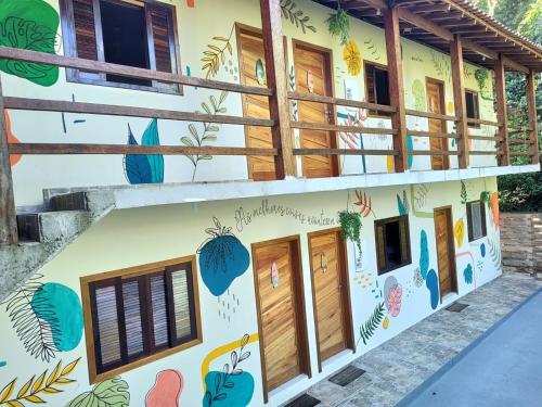 a building with a mural on the side of it at PANTAI POUSADA in Trindade