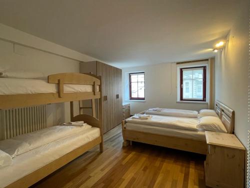 two bunk beds in a room with wooden floors at Appartamento Rio Duron in Campitello di Fassa