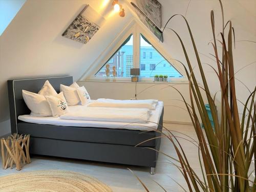 a small bed in a room with a window at Hafenperle 21 - Traum am Hafen in Norddeich