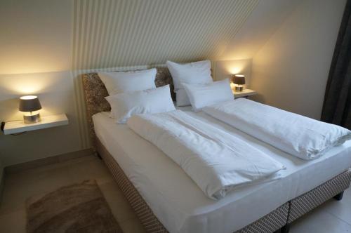 ノルトダイヒにあるKüstenblick 3のベッドルーム1室(白いシーツと枕のベッド1台付)