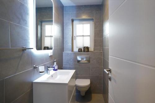 ノルトダイヒにあるKüstenblick 1のバスルーム(洗面台、トイレ、鏡付)