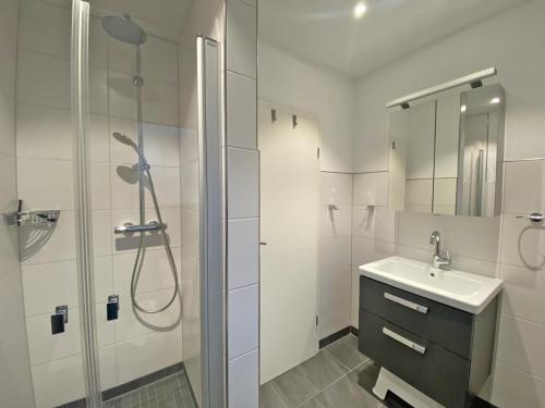 a white bathroom with a sink and a shower at Himmel & Meer in Norddeich