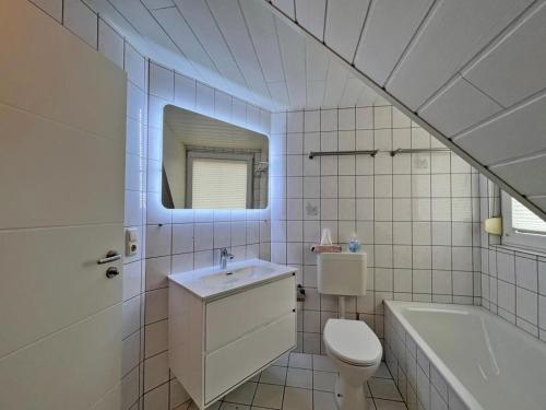 a bathroom with a sink and a toilet and a tub at Deichblick 2 - Traumhaft am Deich in Norddeich