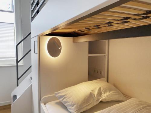 a bed in a room with a bunk bed under a loft bed at Wilde Brise - Ihr Luxusbungalow in Norddeich in Norddeich