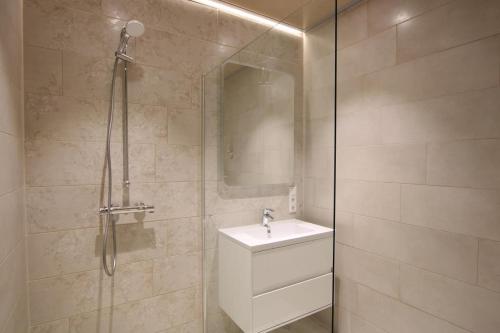 a bathroom with a sink and a glass shower at Seeblick 5 - Luxus am Hafen in Norddeich