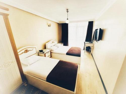 a hotel room with two beds and a television at Seref Hotel in Yalova