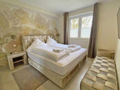 1 dormitorio con cama y ventana en Landblick 4 - Luxusferienhaus für bis zu 7 Personen en Norddeich