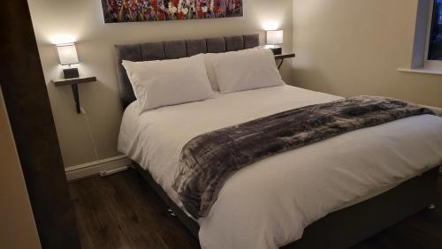 a bed in a bedroom with two lights on at Quiet Enclave on the marina, Free Parking in Hull