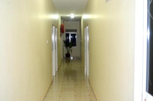 a long hallway with yellow walls and a tile floor at Hotel Top Five in Kampala