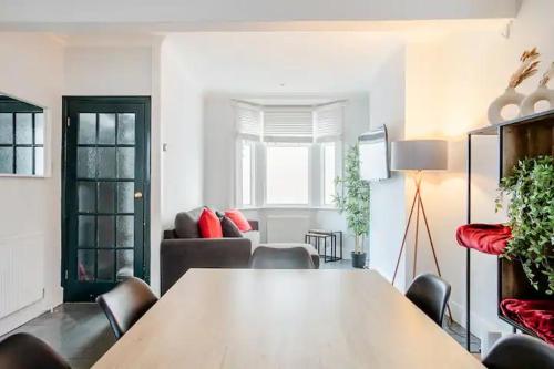 a living room with a table and a couch at Spacious Stratford house in London