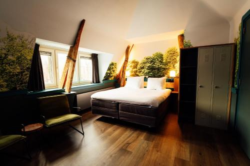 a bedroom with a bed and a chair and windows at Boutique Hotel, Restaurant & Wellness Westerburcht in Westerbork