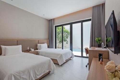 Habitación de hotel con 2 camas y ventana grande. en 可提供早餐的三卧私家泳池家庭别墅 en Ban Huai Yai