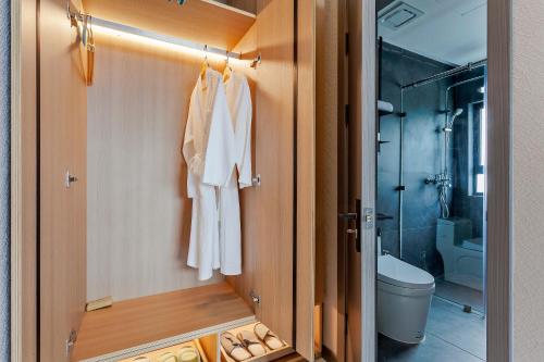 uma casa de banho com um WC e um chuveiro em 可提供早餐的三卧私家泳池家庭别墅 em Ban Huai Yai
