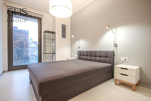 um quarto com uma cama grande e uma janela grande em Ekskluzywny Apartament obok Zamku Wawelskiego em Cracóvia
