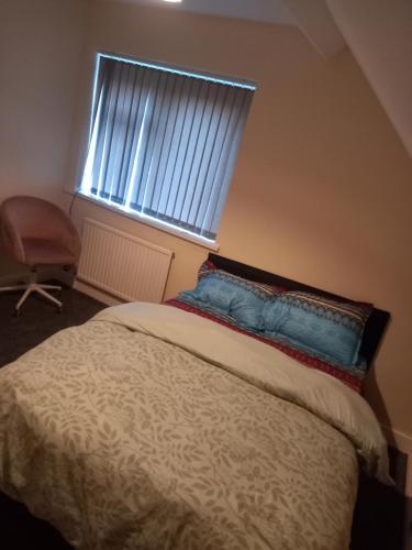 Guest room في Sketty: غرفة نوم بسرير مع نافذة وكرسي