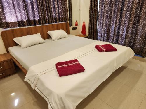 two beds in a room with red towels on them at Hotel Mahadev Family Lodging and Boarding in Neral