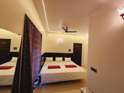 a bedroom with two beds with red towels on them at Hotel Mahadev Family Lodging and Boarding in Neral