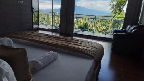 a bedroom with a bed and a large window with a view at Royal Retreat ,Kandy in Kandy