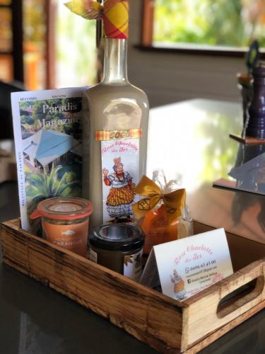 a wooden tray with a bottle of wine and other items at Les Frangipaniers de la Pelée in Saint-Pierre