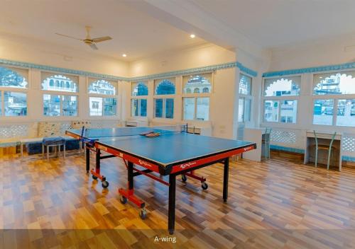 a ping pong table in a large room with windows at Moustache Udaipur in Udaipur