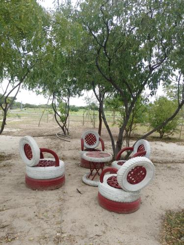 eine Gruppe Stühle, ein Tisch und ein Baum in der Unterkunft Shelta Village View Resort in Mbuguni