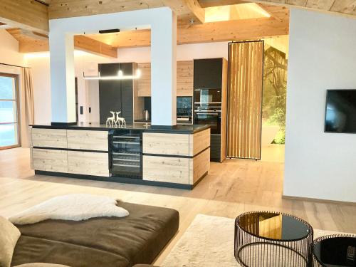 a living room with a couch and a kitchen at Alpen Luxury Lodge, MARIAZELL in Mariazell