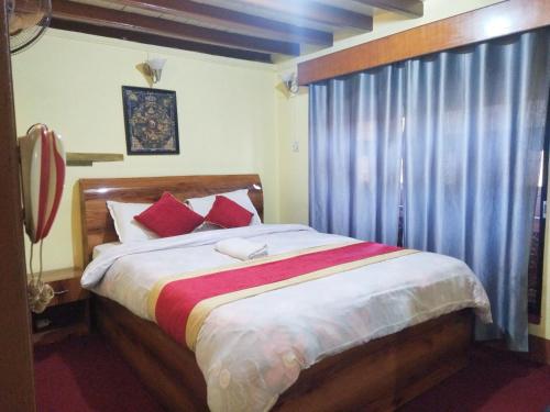 1 dormitorio con 1 cama grande con almohadas rojas en HOTEL RUPAKOT AND ROOFTOP RESTAURANT en Bhaktapur