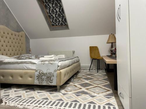 a bedroom with a bed and a desk and a chair at Casa cu Pitici in Vama