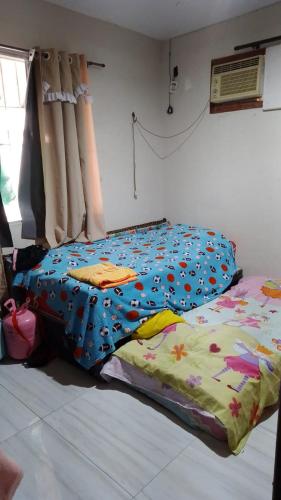 - un lit avec une couette colorée dans une chambre dans l'établissement Casa do Braga, à Cabo Frio