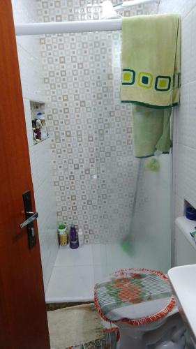 La salle de bains est pourvue d'une douche et d'une serviette verte. dans l'établissement Casa do Braga, à Cabo Frio